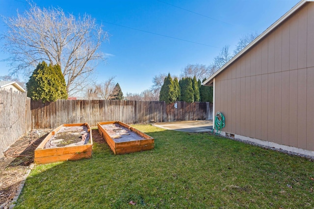 view of yard with a patio area, a garden, and a fenced backyard