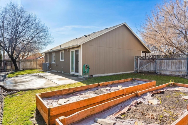 rear view of house with a yard, a patio area, a fenced backyard, and central air condition unit