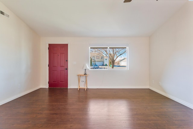 unfurnished room featuring visible vents, baseboards, ceiling fan, and dark wood-type flooring