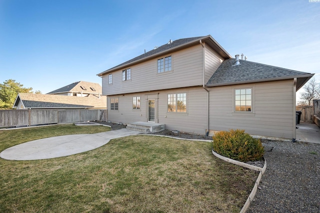 rear view of house featuring a patio area, a lawn, roof with shingles, and fence