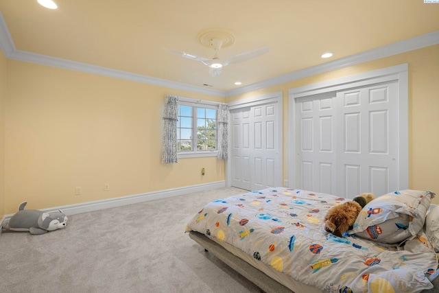 bedroom with two closets, crown molding, baseboards, carpet, and recessed lighting