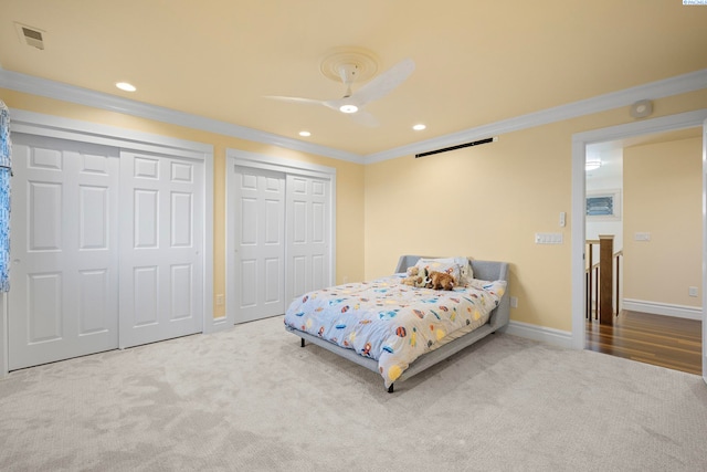 carpeted bedroom featuring recessed lighting, baseboards, two closets, and ornamental molding