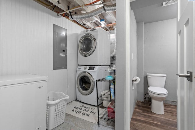 clothes washing area with stacked washer / drying machine and electric panel