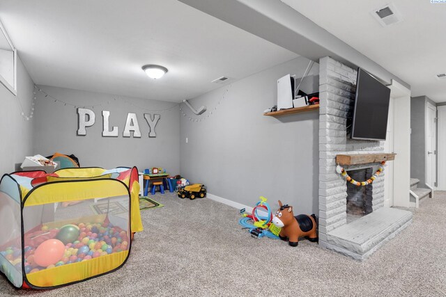 game room with a fireplace and carpet floors