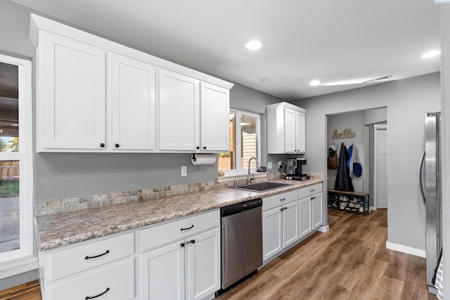 kitchen with sink, dark wood-type flooring, stainless steel appliances, and white cabinets