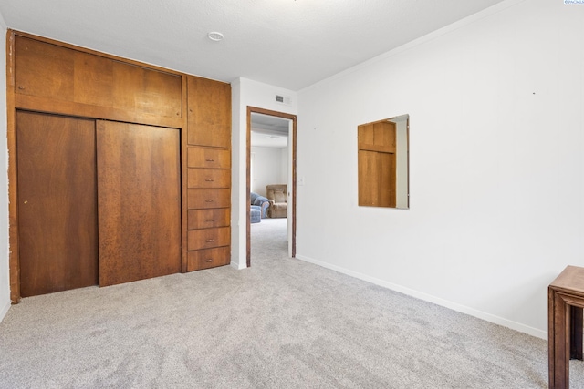 unfurnished bedroom featuring light colored carpet and a closet