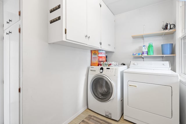 washroom featuring cabinets, separate washer and dryer, and light wood-type flooring