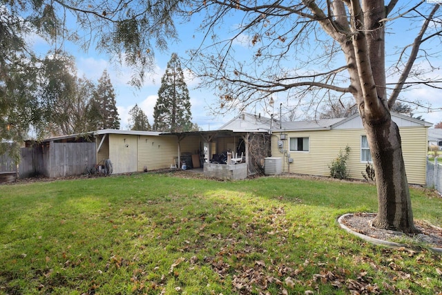 rear view of house with a yard and central air condition unit