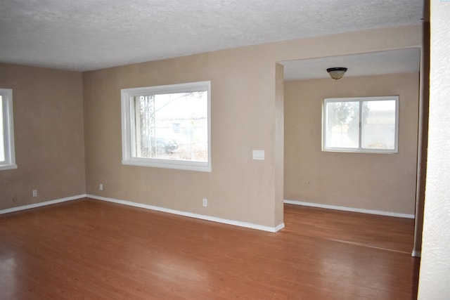 empty room featuring a textured ceiling and wood-type flooring