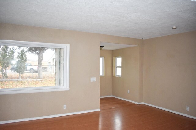 empty room featuring hardwood / wood-style flooring and a textured ceiling