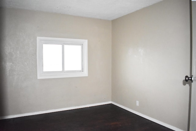 spare room featuring dark wood-type flooring