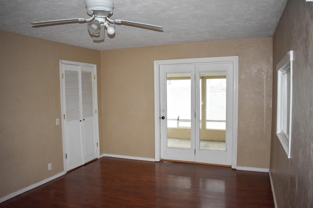 spare room featuring a textured ceiling, dark wood-type flooring, and ceiling fan