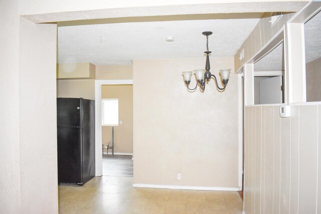 unfurnished dining area with a notable chandelier