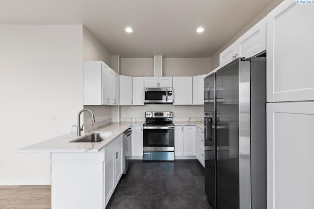 kitchen with appliances with stainless steel finishes, sink, and white cabinets