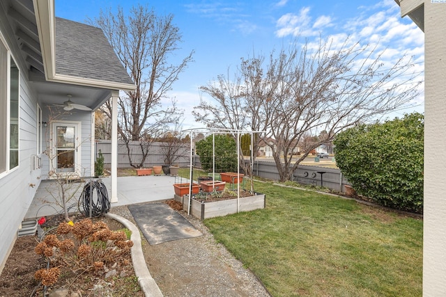 view of yard with a patio area, a garden, fence, and ceiling fan