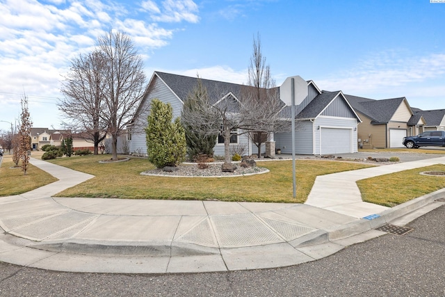 view of front of house with driveway, a residential view, an attached garage, a front lawn, and board and batten siding