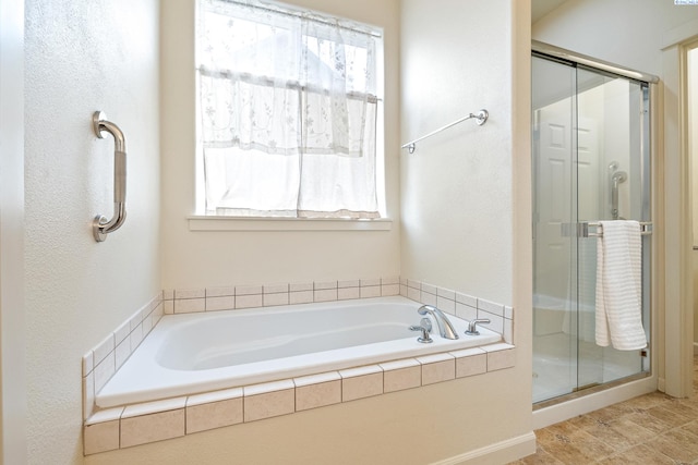 bathroom featuring a garden tub and a shower stall