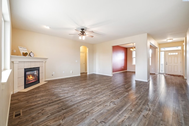 unfurnished living room featuring dark wood-type flooring, a fireplace, visible vents, and baseboards