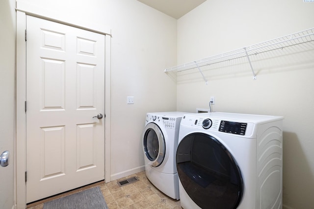 washroom with laundry area, baseboards, visible vents, and independent washer and dryer