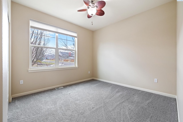 spare room featuring carpet floors, baseboards, and visible vents