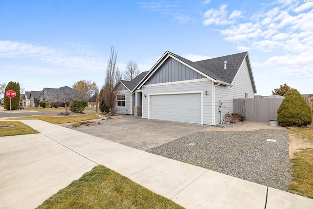 view of front of house with a garage, fence, driveway, roof with shingles, and board and batten siding