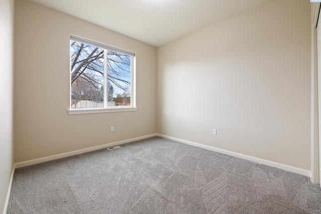 empty room featuring carpet floors, baseboards, and visible vents