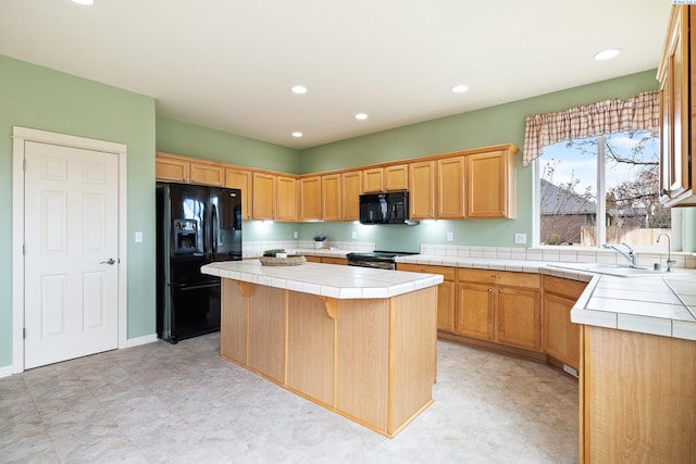 kitchen with tile counters, a center island, black appliances, a sink, and recessed lighting