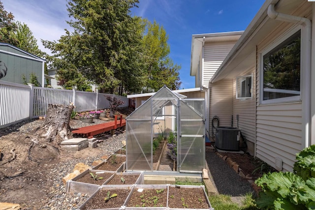 485 NW Thomas St, Pullman, WA 99163 - fenced backyard featuring a greenhouse, a garden, central air condition unit, and an outbuilding