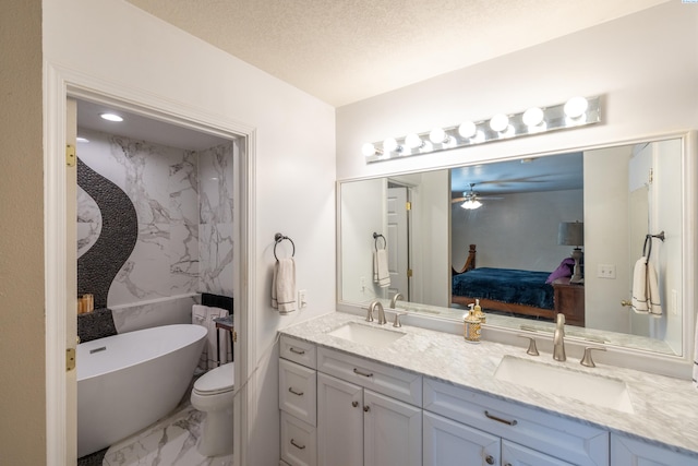 485 NW Thomas St, Pullman, WA 99163 - ensuite bathroom with marble look tiles, double vanity, a freestanding bath, a ceiling fan, and a textured ceiling