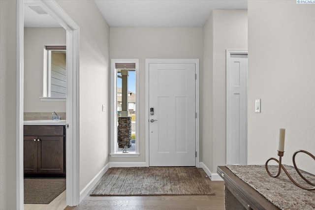 foyer entrance featuring light wood finished floors and baseboards