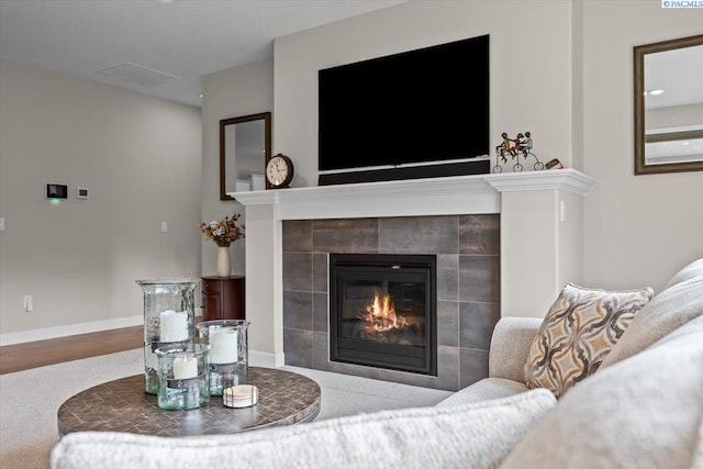 living area featuring a fireplace and baseboards