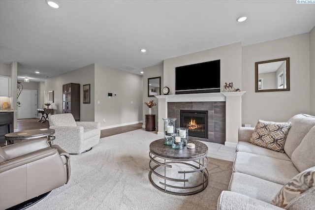 living area with recessed lighting, baseboards, and a tile fireplace