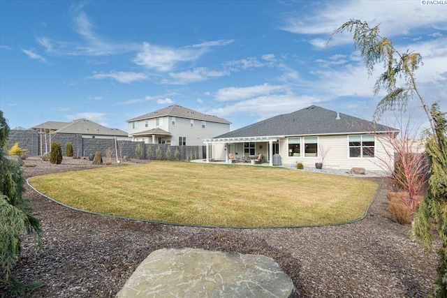 back of house with a yard, a fenced backyard, and a patio