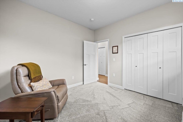 living area featuring carpet floors and baseboards