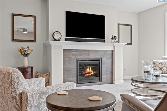 interior space featuring carpet, a tile fireplace, and baseboards