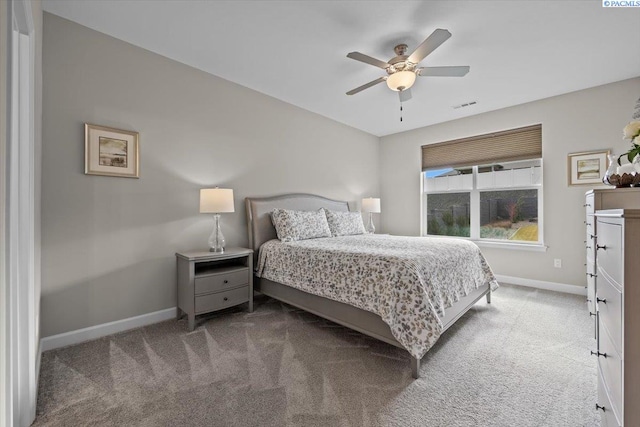 carpeted bedroom featuring ceiling fan, visible vents, and baseboards