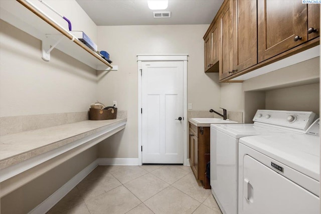 laundry area featuring cabinets, light tile patterned floors, sink, and washing machine and clothes dryer