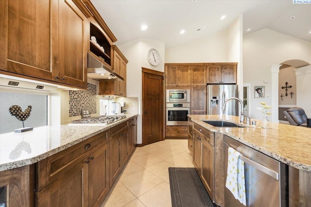 kitchen featuring light stone counters, sink, light tile patterned floors, and stainless steel appliances