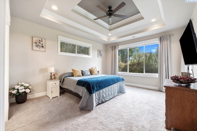 carpeted bedroom with a raised ceiling, crown molding, and ceiling fan