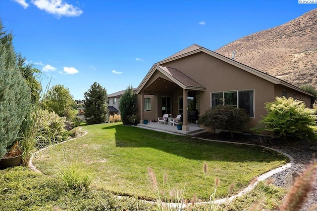 back of house with a patio and a yard