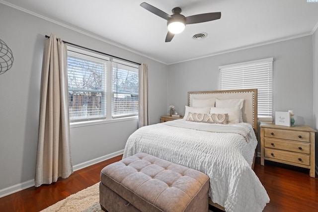 bedroom featuring crown molding, wood finished floors, visible vents, and baseboards