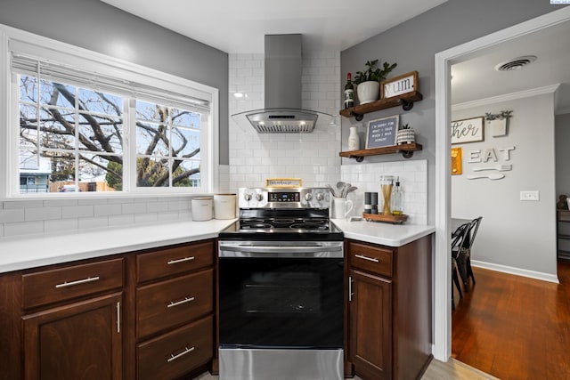 kitchen featuring visible vents, decorative backsplash, stainless steel range with electric cooktop, ventilation hood, and wood finished floors