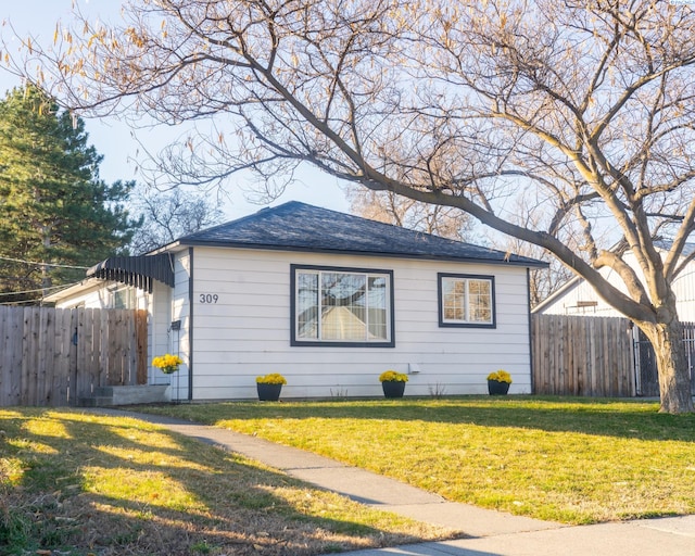 view of property exterior featuring a lawn and fence