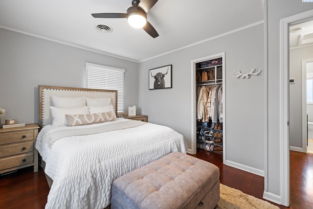 bedroom with a closet, visible vents, ornamental molding, wood finished floors, and baseboards