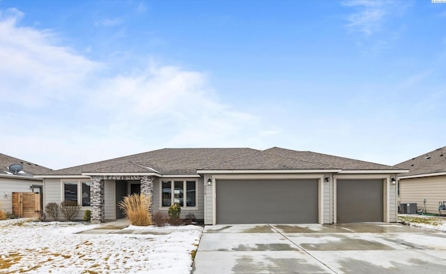 view of front of house with a garage and central air condition unit