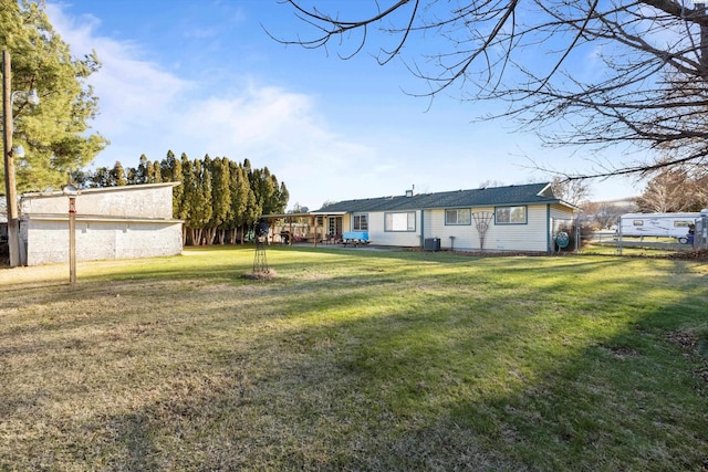 rear view of property featuring a yard and central AC