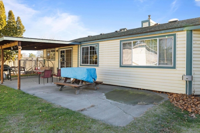 back of house featuring a patio area and a lawn