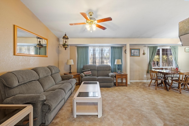 carpeted living room with a wealth of natural light, ceiling fan, and vaulted ceiling