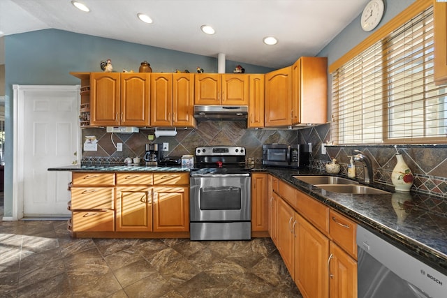 kitchen with lofted ceiling, appliances with stainless steel finishes, sink, and backsplash