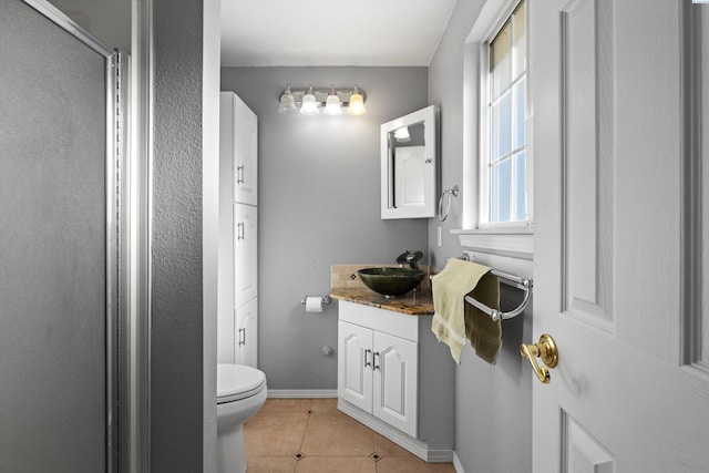 bathroom featuring tile patterned flooring, vanity, an enclosed shower, and toilet